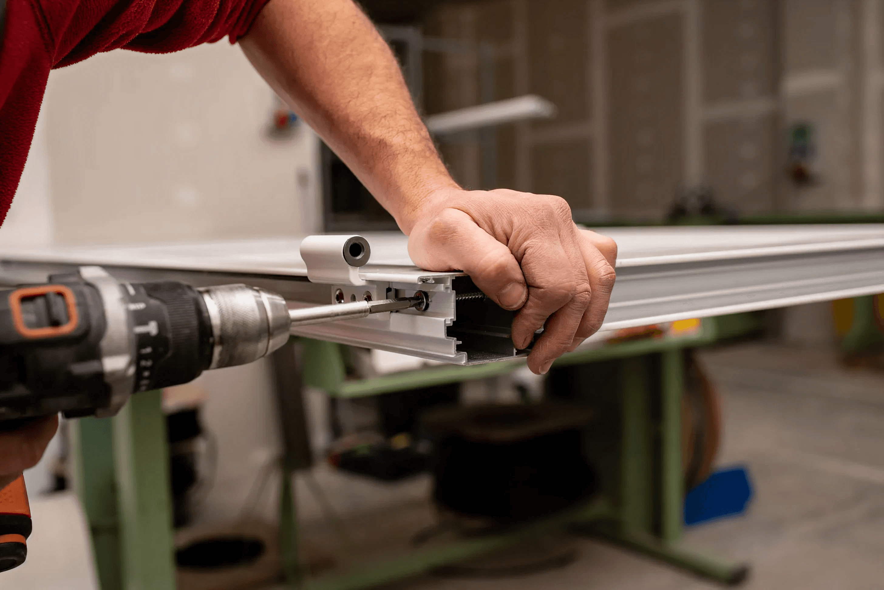 Technician repairing a storefront frame with a drill